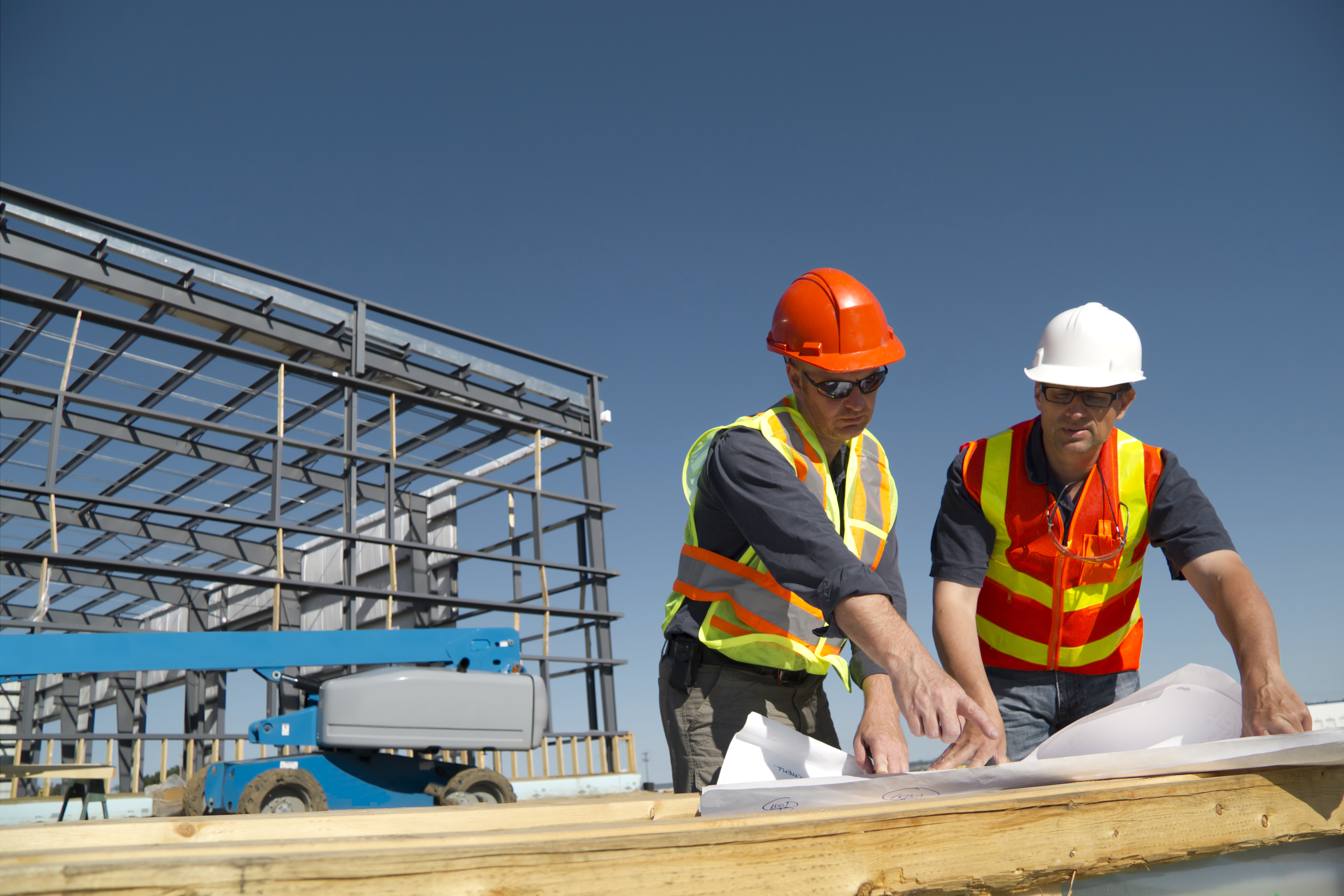 Construction Workers Looking At Plans Onsite (1)